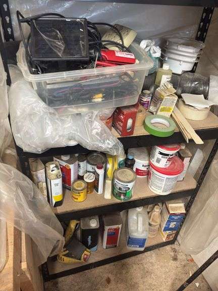 Metal shelving unit with lots of painting supplies