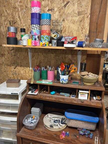 Small desk with lots of crafting items lots of tape, popsicle, sticks, rocks