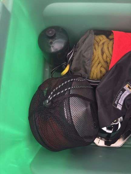 Large tote full of camping supplies, including sleeping bags, camping cookware set, propane burner, bag of rope and more
