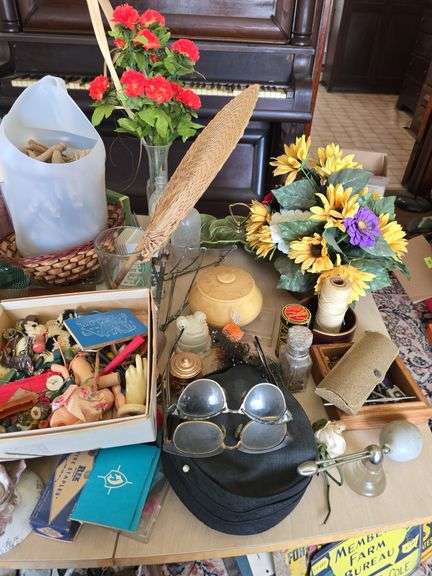 On top of table includes wooden clothes pins, old spectacles, rosaries, pottery, etc