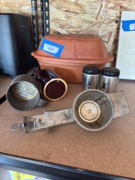 Vintage kitchen items, including ceramic bread pan, salt and pepper shakers, shredder, tin cup with advertising, and pabst Milwaukee stoneware mug