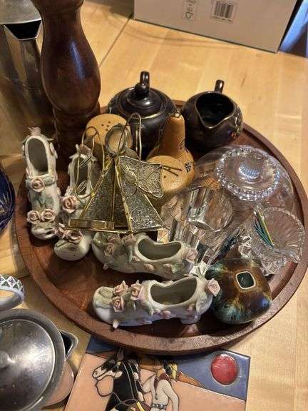 Decorative items on wooden tray, glass shoes, trivet, glassware, cream and sugar etc