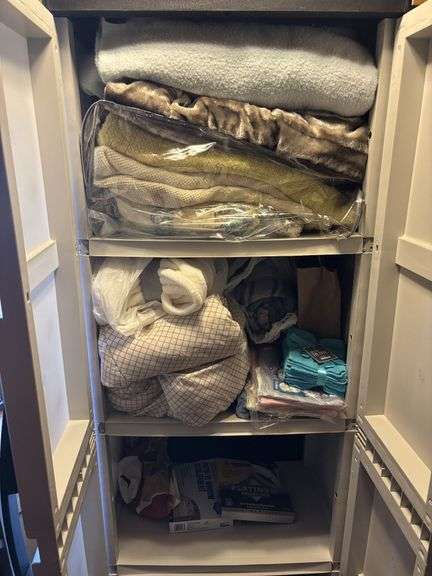 Double door plastic storage cupboard and contents - mostly blankets and linens
