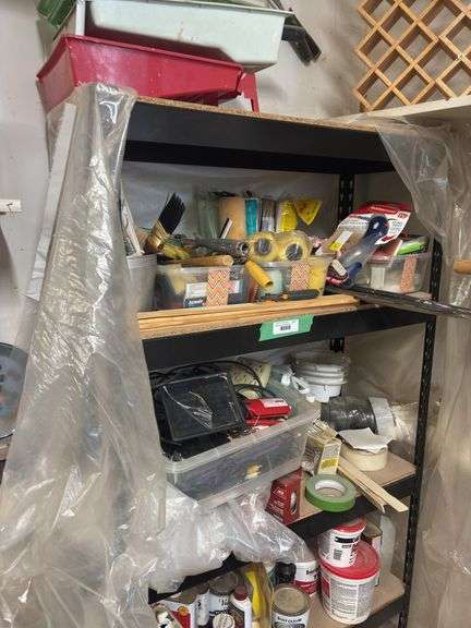 Metal shelving unit with lots of painting supplies