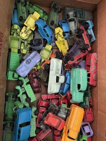 Box of toy cars, many appear to be Tootsie Toys
