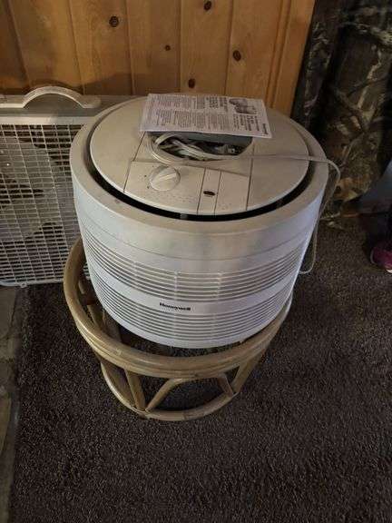 Two box fans and an air purifier on hassock stand