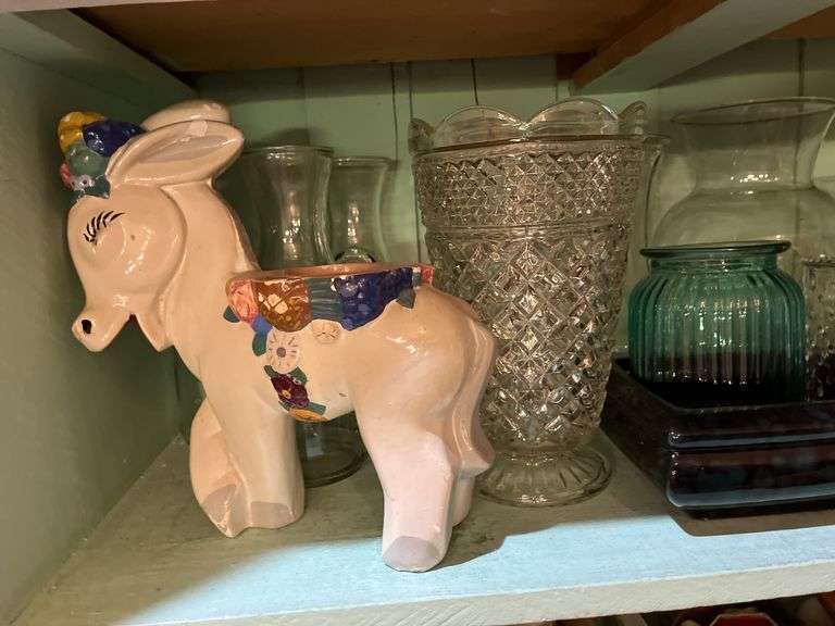 Contents of cupboard include vases, coffee mugs, TV lamp, etc