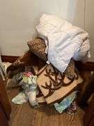 Various linens include blankets, pillows, sheets, rug