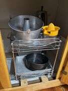 Lower cupboard contents in kitchen - bakeware, pans, colander, plasticware