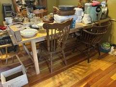 Large light pine dining room table with one self storing leaf and 5 mismatched chairs
