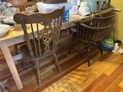 Large light pine dining room table with one self storing leaf and 5 mismatched chairs