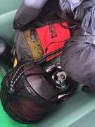Large tote full of camping supplies, including sleeping bags, camping cookware set, propane burner, bag of rope and more