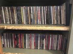 Two shelves full of DVDs and CDs