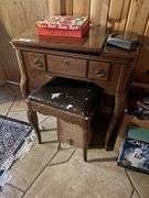 Singer sewing machine in table with bench and lots of additional sewing items in the bench