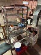 Metal shelving unit with contents, office chair, tool boxes and plastic stackable storage bins with empty coffee cans