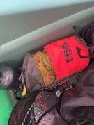 Large tote full of camping supplies, including sleeping bags, camping cookware set, propane burner, bag of rope and more