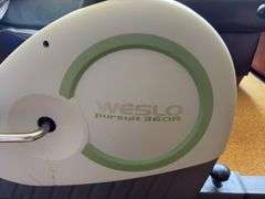 Weslo Pursuit 360R exercise bike and a pair of stainless steel dumbbells