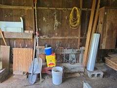 Car ramps, log chain, tire chains, scoop shovel, grease gun, large roll of plastic sheeting