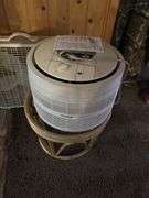 Two box fans and an air purifier on hassock stand