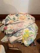 Various linens include blankets, pillows, sheets, rug