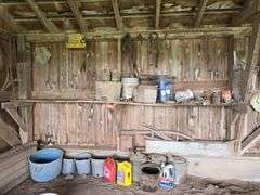 Oil, old gas cans, buckets, cast iron skillet, nails and more All on and under shelf