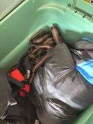 Large tote full of camping supplies, including sleeping bags, camping cookware set, propane burner, bag of rope and more