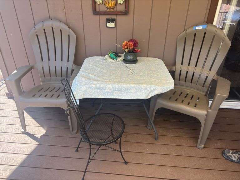 Two plastic Adirondack style chairs, glass top patio table and wrought iron patio chair image