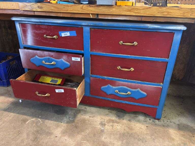 Red and blue painted six drawer dresser used in wood shop for storage image