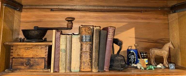 Hand crank wood coffee grinder, old books, carved horse and shovel image