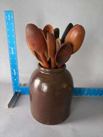 Albany slip crock jar full of of wooden spoons image