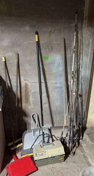 Pushbroom, two dust pans, old snow shovel and two other brooms, fishing poles and tackle box image