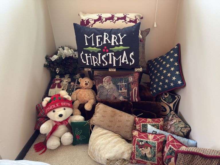 Luggage rack, lots of throw pillows and two stuffed teddy bears image