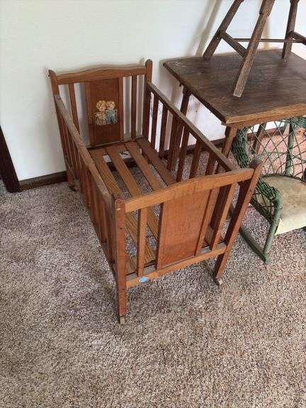 Doll crib, green wicker doll rocker, child’s table and chair