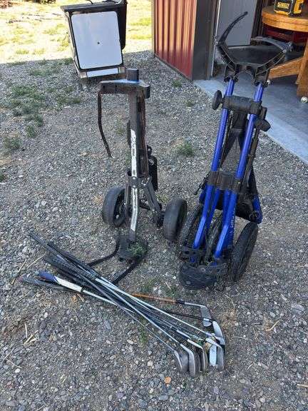 Golf bag carts and assorted clubs image
