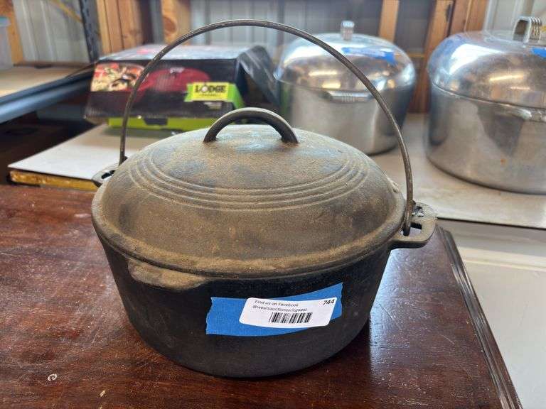 Cast-iron Dutch oven with bale handle 10 inches wide 4 inches deep marked with an eight on the bottom image