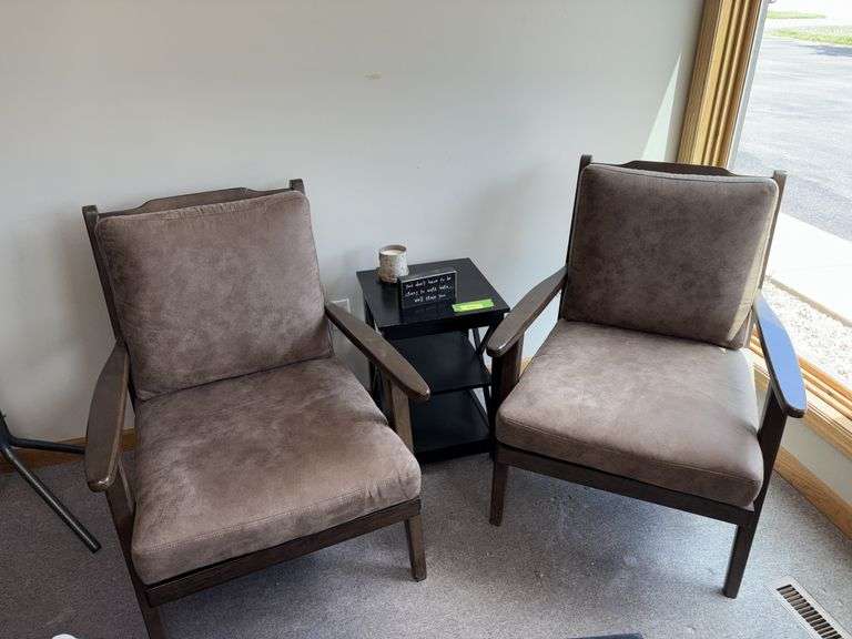 Two padded arm chairs with throw pillows, small side table and decor