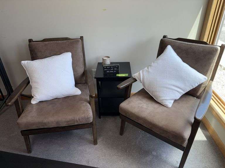 Two padded arm chairs with throw pillows, small side table and decor image