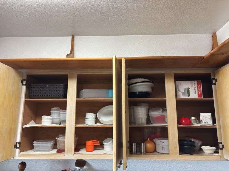 Three upper cupboards in kitchen, including glasses and coffee mugs lots of plastic storage containers, heavy ceramic bowl, salad spinner image