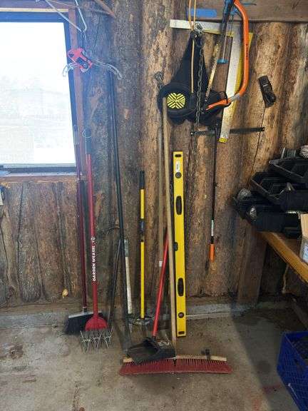 Items on shop wall includes garden weasel, level, large spud bar, crowbar, kneepads, shop magnet, hand saw, squares image
