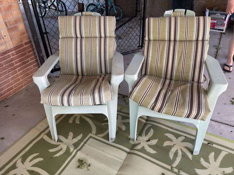 Two light green patio chairs with cushions image