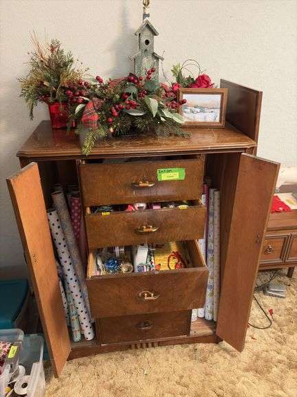 Contents of dresser include holiday decor, wrapping paper, tissue paper, ribbon and bags image