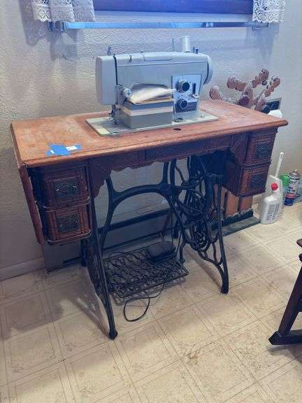 Ornate antique treadle sewing machine table with wood cover, drop leaf, four drawers and vintage Sears Kenmore sewing machine plus sewing notions in drawers image