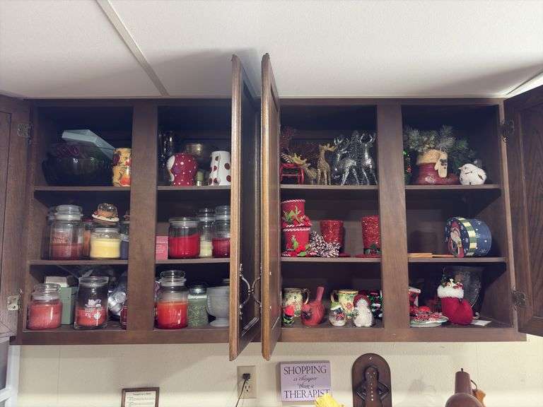 Cupboard full of partially burned candles and holiday decor image