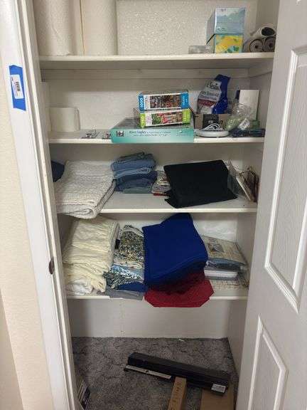 Linen closet with various towels, linens, blankets, puzzles, home ware type items image