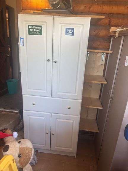 White storage cupboard with miscellaneous kitchen wares and plastic ware image