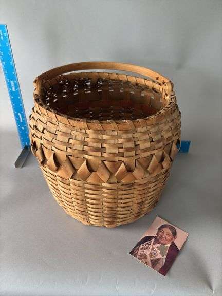 11” across opening, 12” tall woven basket with handle Believe this to be an Emma Big Bear basket, local Marquette basket maker, check out the story about the basket maker, link in description Still has color inside basket image