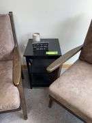 Two padded arm chairs with throw pillows, small side table and decor