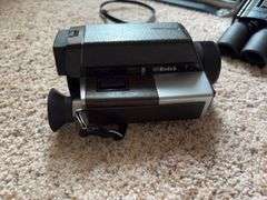 Projector screen, Bushnell 12x32 binoculars, Canon PowerShot A590 digital camera,  Kodak XL33 movie camera
