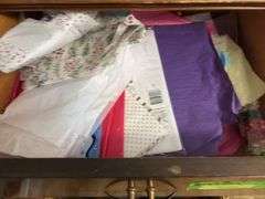 Contents of dresser include holiday decor, wrapping paper, tissue paper, ribbon and bags