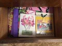 Contents of dresser include holiday decor, wrapping paper, tissue paper, ribbon and bags